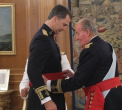 Don Juan Carlos impone a Su Majestad el Rey la faja de capitán general